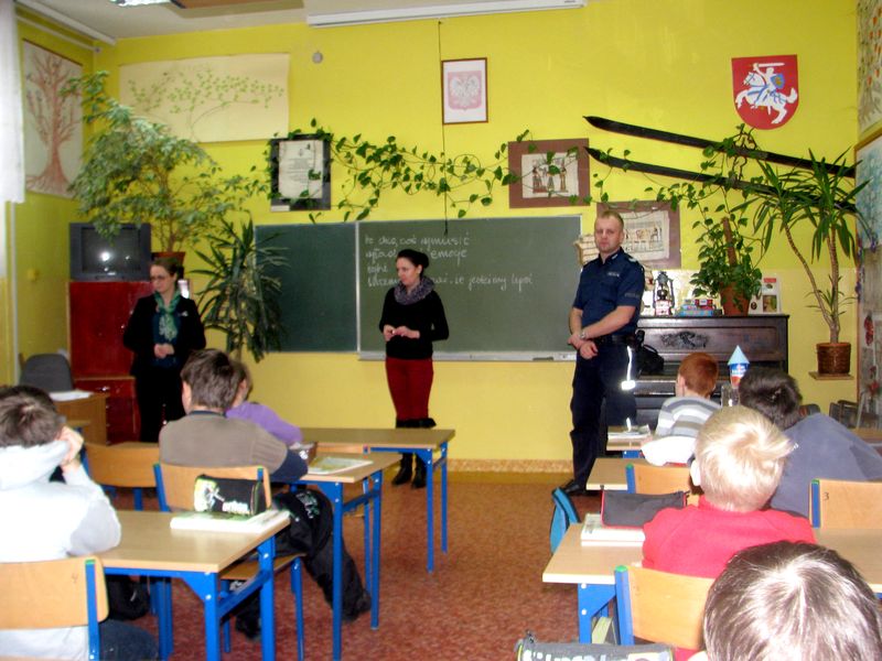 Obraz: Zdjęcie przedstawia przedstawicieli PCPR-u oraz Pana Policjanta w sali lekcyjnej z uczniami klas 5 i 6 szkół podstawowych - kliknięcie spowoduje powiększenie elementu do rozmiarów oryginalnyc